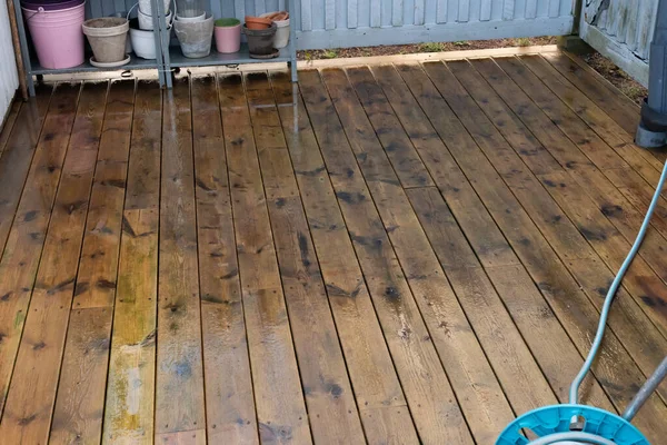 Newly cleaned wooden deck of a porch.