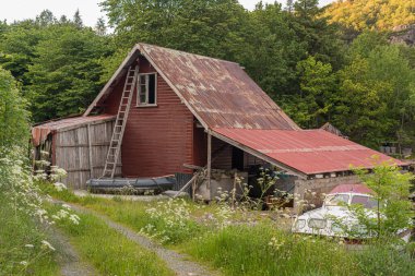 Lindesnes, Norveç - 19 Haziran 2015: Merdiveni ve kırık penceresi olan eski kırmızı ahşap kayıkhane.