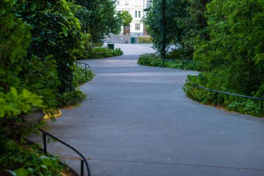 Malmö, İsveç - 09 Temmuz 2022: Çalılar arasında beton yürüyüş yolu.