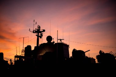Sunset silhouette of a warship.