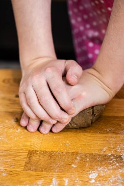 Hands making gingerbread cookies.