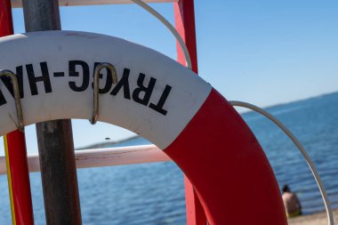 Gothenburg, Sweden - June 24 2022: Closeup of a red and white lifebuoy by the sea.