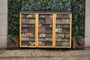 Insect hotel placed by the side of a street.