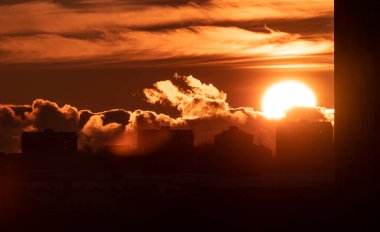 Sun setting behind apartment buildings.