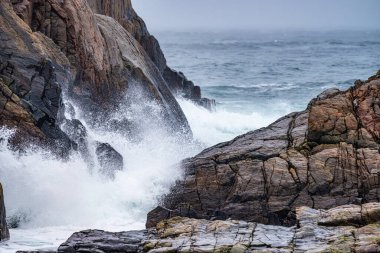 Waves crashing against cliffs during a winter storm.