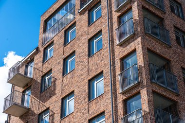 Looking up a tall newly constructed brick apartment building.
