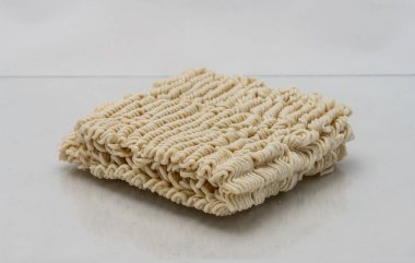 Dry instant ramen noodles on white background.