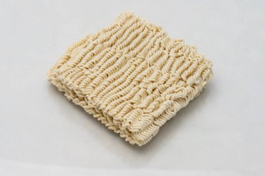 Dry instant ramen noodles on white background.