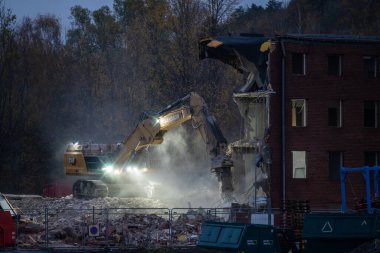 Gothenburg, Sweden - October 25 2022: Large excavator demolishing a brick office building.