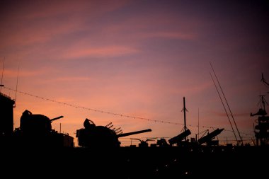 Sunset silhouette of a warship.