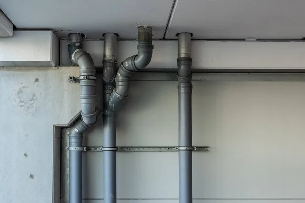 Drain pipes coming down through the roof from an above floor.