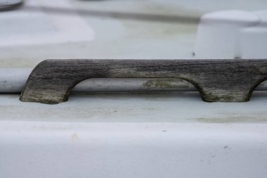 Old untreated wooden railing on a sailboat.