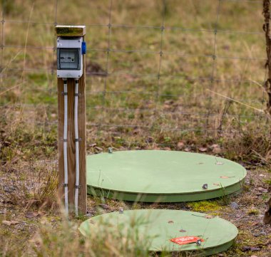 Göteborg, İsveç - Kasım 05 2022: Elektrik pompalı bir kuyunun yanındaki sigorta kutusu.