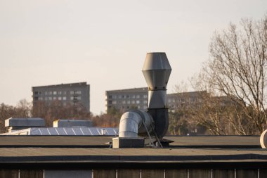 Ventilation duct and fan on the roof of a building.