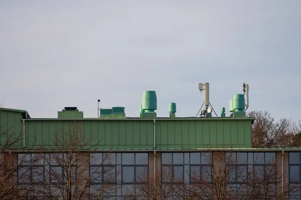 Ventilation funnels and communications antennae on the roof of a building.