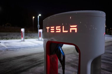 Gothenburg, Sweden - december 09 2022: Cars charging at Tesla Superchargers at night.