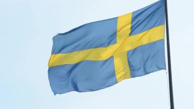 Güneşli bir günde rüzgarda sallanan İsveç bayrağı.