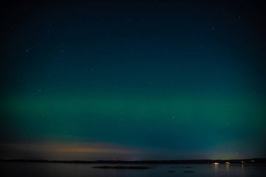 Bir fiyort üzerinde yeşil kuzey ışıkları.