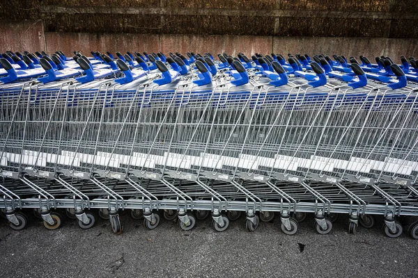 Hosszú Sorok Üres Bevásárlókocsik Várnak Ügyfelekre Egy Bevásárlóközpont Mellett — Stock Fotó