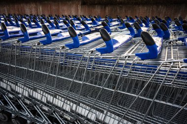 Alışveriş merkezinin önünde müşterileri bekleyen uzun sıra boş alışveriş arabaları..