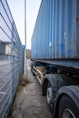 Çit ve direğin yakınına park edilmiş konteynırlı bir karavan..