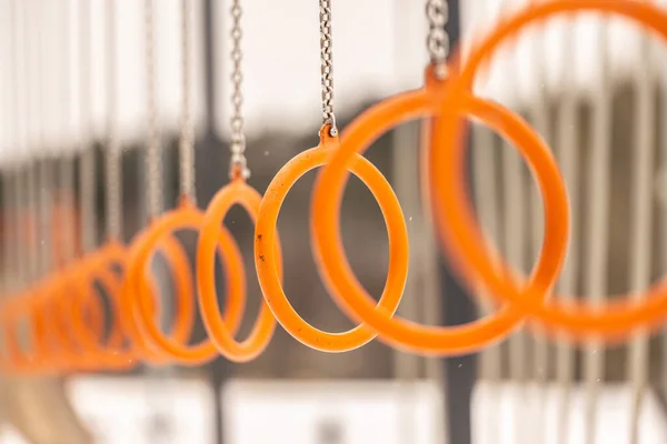 orange metal rings of an obstacle course in a park.