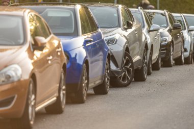 Göteborg, İsveç - 03 Ekim 2022: Yolun kenarına park edilmiş uzun bir sıra araba.