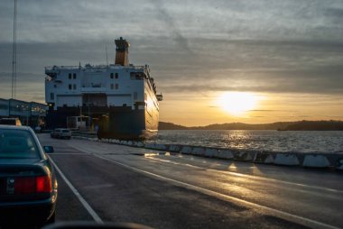 Stromstad, İsveç - 22 Aralık 2006: Arabalar gün batımında feribota biniyor.