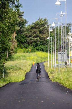 Bicyclist riding down a bike road.