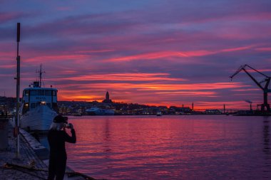 Göteborg, İsveç - 11 Ocak 2019: Limanın üzerinde renkli pembe ve mavi gün batımı.