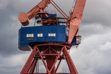 Göteborg, İsveç - 16 Ağustos 2021: Eski bir rıhtımda kullanılmayan kırmızı ve mavi vinç.