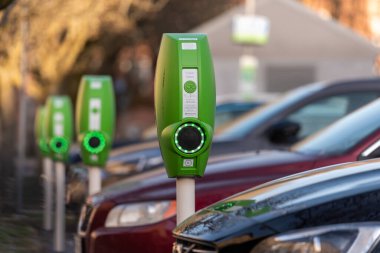 Göteborg, İsveç - 01 Mayıs 2022: Kamu EV elektrikli araç bir otoparkta elektrik direklerini şarj ediyor.