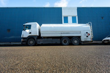 Göteborg, İsveç - 26 Ocak 2023: Mavi bir deponun yanına park edilmiş beyaz tanker kamyonu.