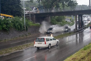 Göteborg, İsveç - 07 Haziran 2022: Su basmış bir altgeçitte derin sularda giden arabalar.