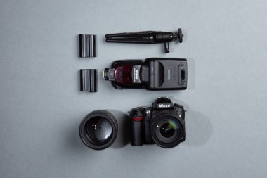 Göteborg, İsveç - 17 Ağustos 2019: Nikon DSLR kamera, flaş, lensler ve piller gri bir masa üzerinde..