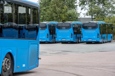 Göteborg, İsveç - 24 Temmuz 2022: Bir depoda uzun sıra mavi otobüsler.