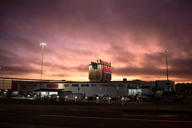 Göteborg, İsveç - 13 Şubat 2023: Tesla süperşarjörleriyle birlikte otoparkta bulunan alışveriş merkezi 421 'in akşam fotoğrafı.