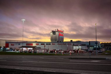 Göteborg, İsveç - 13 Şubat 2023: Tesla süperşarjörleriyle birlikte otoparkta bulunan alışveriş merkezi 421 'in akşam fotoğrafı.