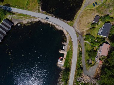 Lindesnes, Norveç - 24 Temmuz 2019: Deniz kenarında dar bir virajın yukarıdan çekilmiş fotoğrafı. Siyah araba yolda gidiyor..