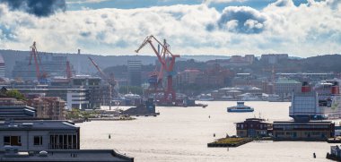 Göteborg, İsveç - 02 Haziran 2022: Nehirden geçen eski rıhtım vinçleri ve feribotlarıyla Göteborg 'un iç limanı.