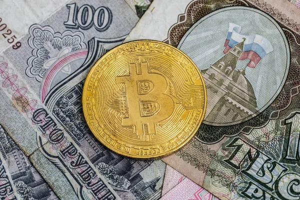 stock image Gothenburg, Sweden - April 30 2022: Shiny golden Bitcoin placed on old russian ruble notes.