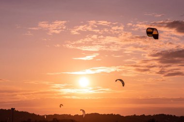 Göteborg, İsveç - 10 Ekim 2021: Kiteboardcular gün batımında plajda uçurtma sörfü yapıyorlar.