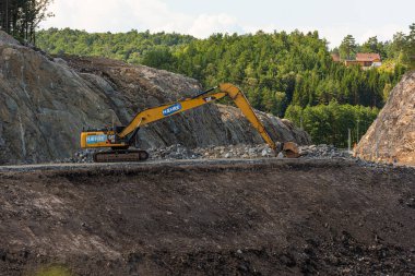 Kristiansand, Norveç - 01 Ağustos 2021: Otoyol inşaatında büyük kedi kazıcısı kullanıldı.