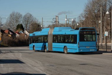 Göteborg, İsveç - 27 Şubat 2022: Mavi Volvo 7700 CNG yolcu otobüsü bir otobüs durağında.