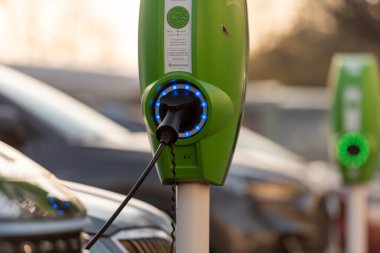Göteborg, İsveç - 01 Mayıs 2022: Kamu EV elektrikli araç bir otoparkta elektrik direklerini şarj ediyor.