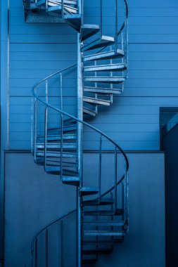 Büyük gri bir deponun sarmal merdivenleri..