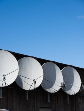 Bir binanın ön cephesinde dört parabolik anten..