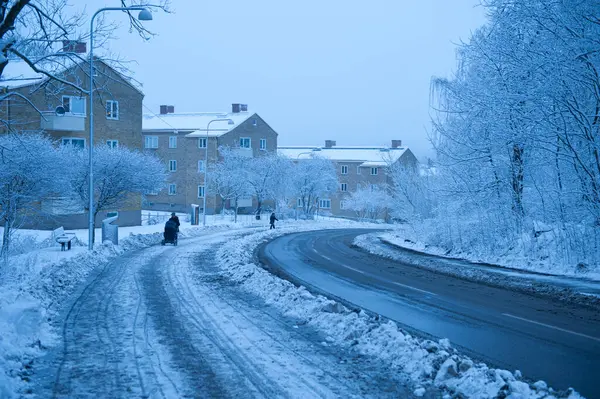 寒い冬の日に曲がった道を歩いている人々 ロイヤリティフリーのストック画像