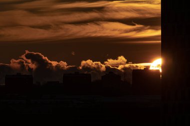 Sun setting behind apartment buildings.