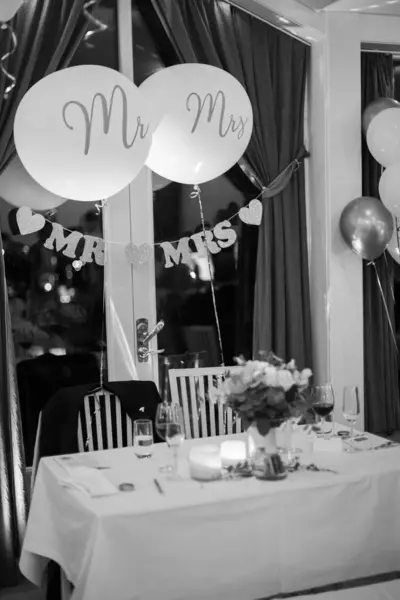 Bride and groom table at a wedding decorated with balloons.
